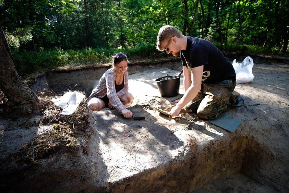 dos jóvenes arqueólogos en una excavación.